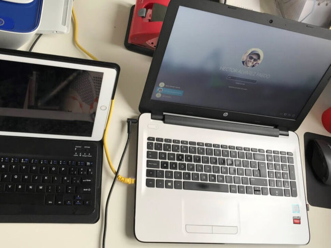 Escritorio de Héctor Alvarez Faedo en 2021: ordenador portátil HP, Ipad Air de Apple con funda-teclado e impresora HP